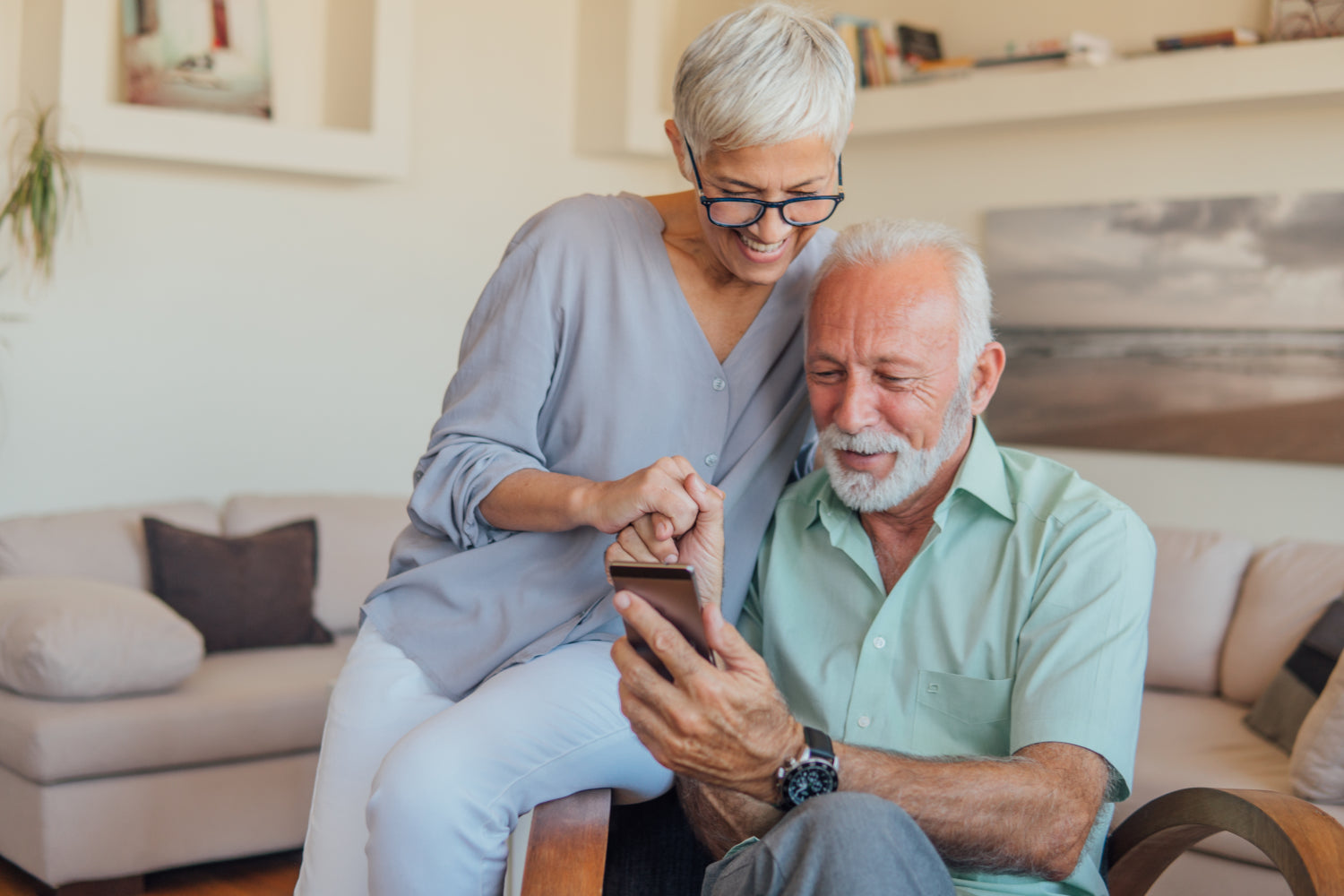 Happy elder couple using iHeart Remote app in their smartphone